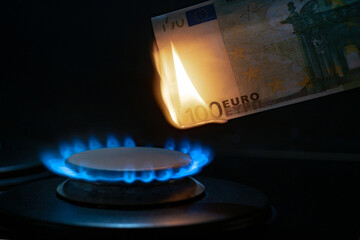 100 euro banknote on a gas burner. The concept of cost for natural gas. Energy crisis. High cost,...