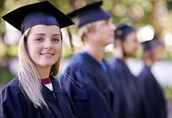 Securing her future. Portrait of a happy graduate standing in a row with her peers waiting for her...