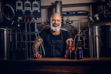 Grandfather brewing business man with tattooed hand in brewery