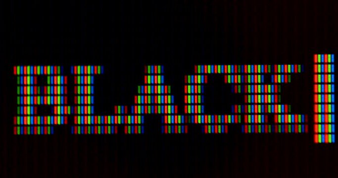 The word black is written in pixel letters on the monitor. RGB font rendering. Color designation. Dark background. The cursor is blinking.