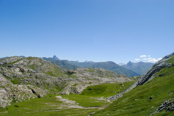 Fototapeta premium Mountainous landscape of long green mountain ranges with a clear blue sky with few clouds