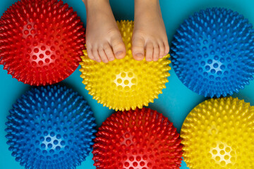 children's feet with a colored balancer on a light blue background, treatment and prevention of...