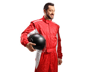 Smiling racer in a red suit holding a black helmet and looking to the side