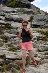 Naklejka premium junge frau geht auf felsigem weg