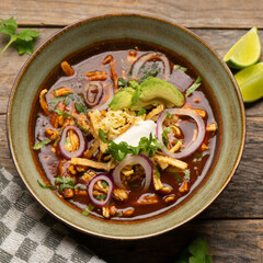 Tortilla soup with avocado and cheese. Mexican food