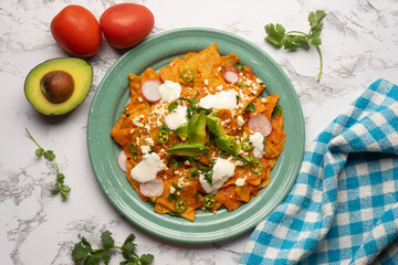 Red chilaquiles with cheese and avocado. Mexican food