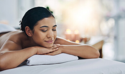 This is what I do after a long day of working. Shot of a relaxed an cheerful young woman getting a massage indoors at a spa.
