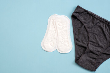 Top view white sanitary napkin and underpants isolated on blue background. Woman hygiene, Concept of critical days, menstruation,health care