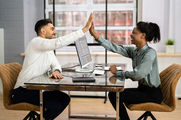 Businessman And Businesswoman Sitting On Chair Giving High Five