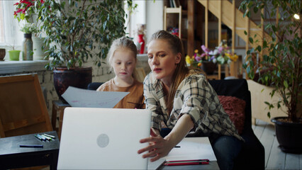 A woman is looking for drawing lessons on the Internet to spend time with her daughter