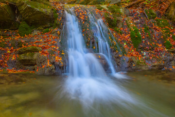 Fototapeta na wymiar small mountain river with waterfall in mountain canyon, autumn outdoor mountain scene