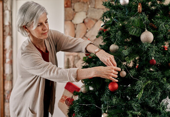 You can go right here. Cropped shot of a carefree mature woman placing decorations on a Christmas...