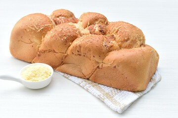 Big bread with cheese, grated parmesa cheese on white wooden background