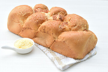 Big bread with cheese, grated parmesa cheese on white wooden background