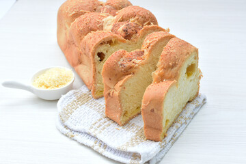 Big bread with cheese, grated parmesa cheese on white wooden background