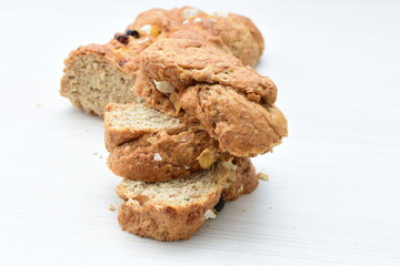 Healthy wholemeal big bread, with cereals, raisins, peanuts and honey on white wooden background