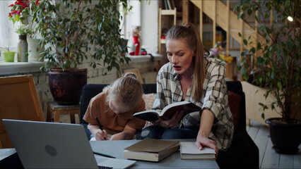 A woman dictates a text from a textbook to a girl, and she writes down