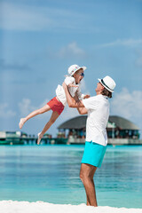 Happy father and his adorable little daughter at tropical beach walking together