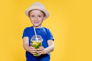 Fototapeta premium Summer refreshment. Cold beverage. Little boy with plastic cup of fresh lemonade