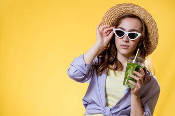 Summer refreshment. Cold beverage. Happy woman in sunglasses holding plastic glass of mojito. Non-alcoholic drink. Detox lemonade