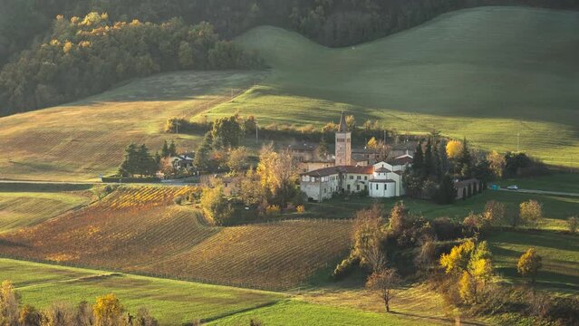 Sunset time lapse over a small village in the countryside with vineyards in autumn, Emilia Romagna, Italy