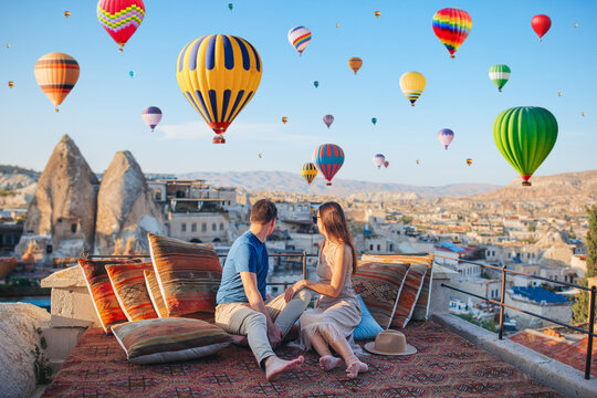 Happy young couple during sunrise watching hot air balloons in Cappadocia, Turkey