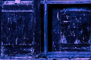 The rough texture of an old wooden door in a blue-lilac hue. Concept of street photography. Graffiti element in design.