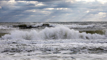 waves breaking on Florida beach with light rays breaking through storm clouds
