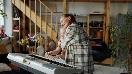 A woman and a child play a cheerful and unobtrusive melody on the piano