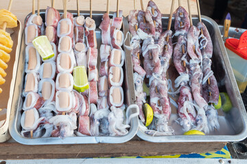 Fresh squid from fishermen stabbed with bamboo to be grilled and sold at culinary festivals, street...