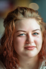 Fototapeta premium Portrait of a beautiful young red-haired plump girl close-up.