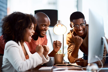 We do se well when we work together. Shot of a group of businesspeople looking at something on a computer screen in an office.