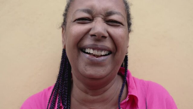 Authentic shot of happy African senior woman smiling on camera