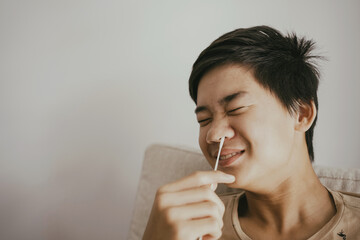 Mixed Asian teen boy getting nasal swab test at home, Covid quick rapid self test, kid antigen test, new normal concept