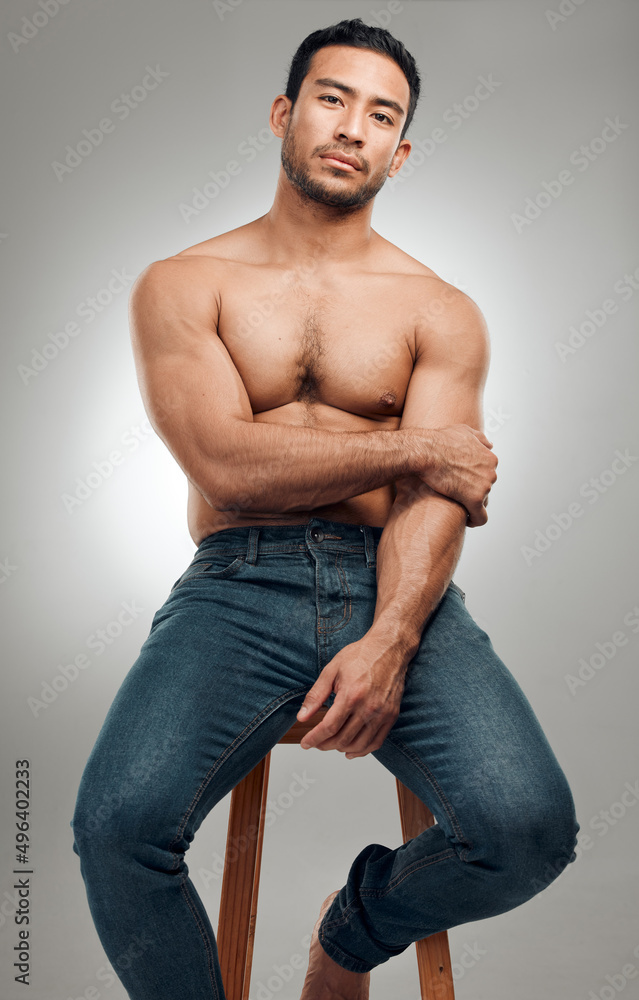 Poster i cant help but be a little arrogant. shot of a handsome young man sitting on a stool in the studio 