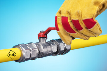 Male hand in glove opens or closes on a gas pipe valve. Stopping the gas supply.