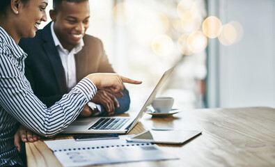 Getting their tasks all in order. Shot of two businesspeople working together on a laptop in an...