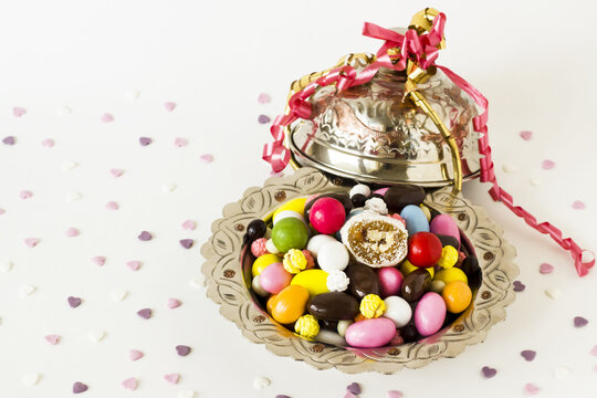 Colorful almond candies, a slice of Traditional Turkish Delight and chocolates designed in vintage silver candy bowls.