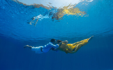 Fototapeta na wymiar Man and Woman swimming underwater