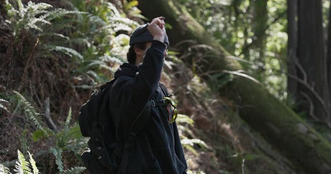 Adult male throws a knife in the forest.