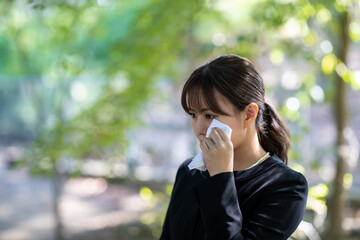 お葬式でハンカチを持って泣く女性
