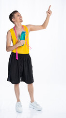 fitness man with a slim body, an athlete in black shorts and a yellow t-shirt with a jump rope around his neck, holds a bottle of water and points his finger to the side.