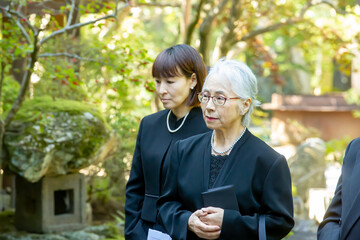 お葬式に参列する喪服の遺族・弔問客
