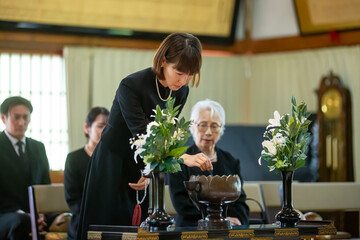お葬式で焼香台に立つ女性（お焼香）
