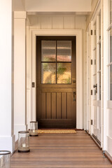 A front door that is brown. entrance down a small corridor. 