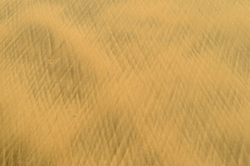 a zig zag pattern formed on the beach sand due to the backflow of sea water that washes the beach