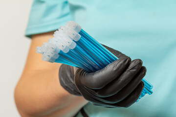 Dentist's hand in glove with saliva ejectors.