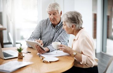Making sound financial decisions. High angle shot of a senior couple working on their finances at...