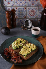 Breakfast with avocado sandwich and fried bacon