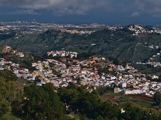 Fototapeta na wymiar Beautiful aerial view of small town Teror in the northeast of island Gran Canaria, Canary Islands, Spain surrounded by green hills on cloudy day.
